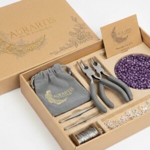 Kit de inicio Esencial Box de Aurartis con herramientas, cuentas moradas y fornituras de plata para joyería artesanal.